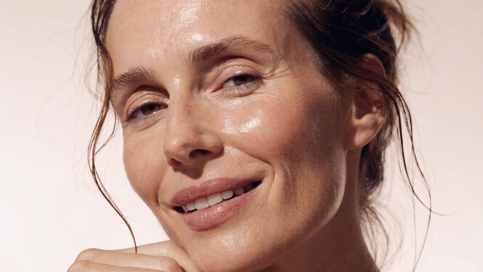 A woman in her thirties with a clean bare face and hair loosely tied back.